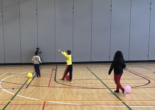 Children play with balloons in the gym