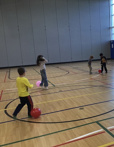 Children play with balloons in the gym