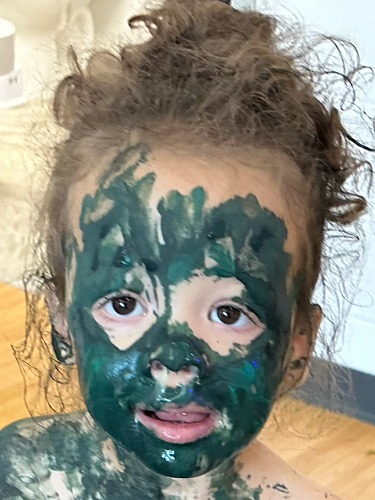 A child is covered in paint