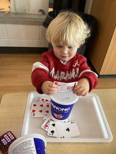A child inserts cards into a container