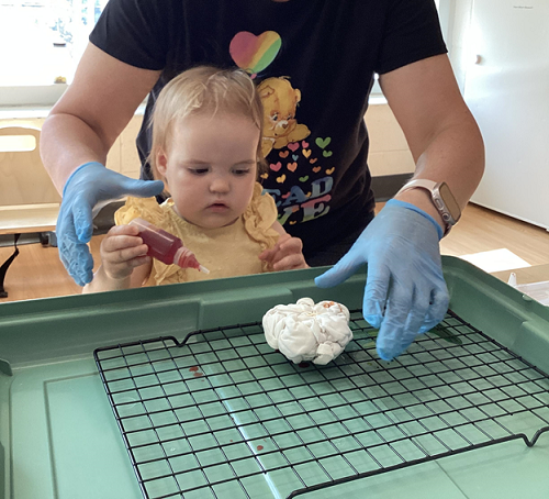 A child doing tie-dye with an educator.