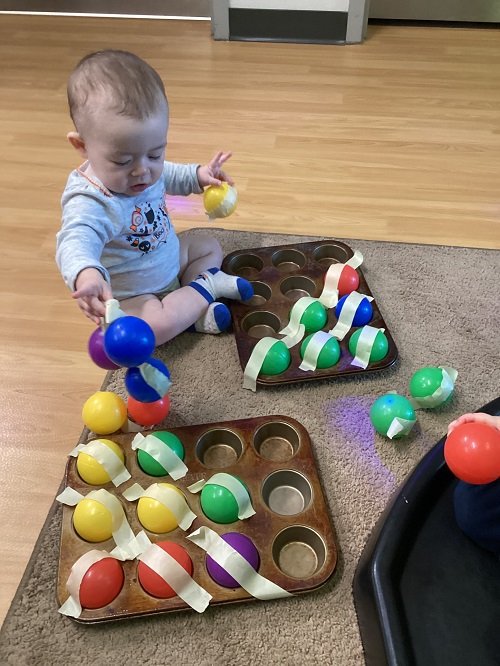 A child holding yellow and blue tape-covered balls.