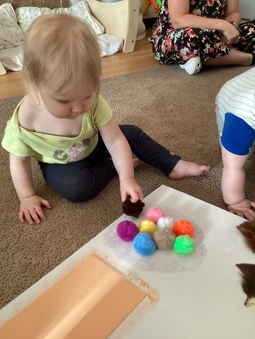 An infant child exploring a sensory board