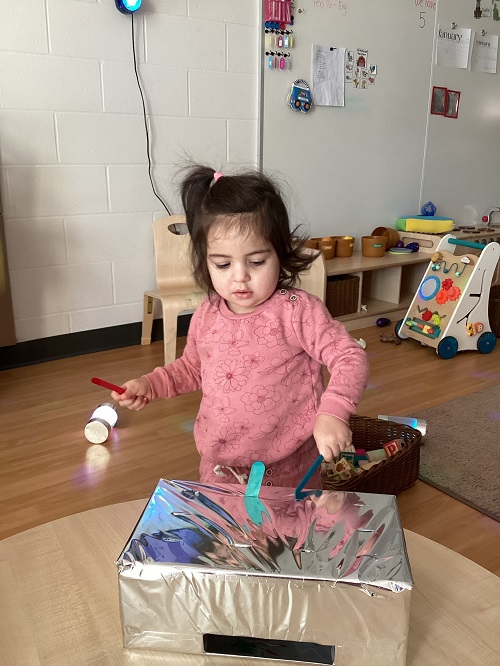 A child observing and exploring the shiny box