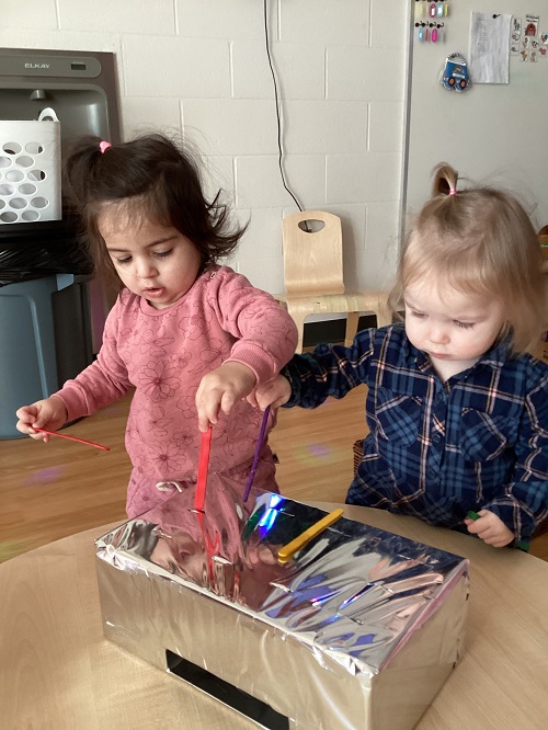 Two children exploring the shiny box