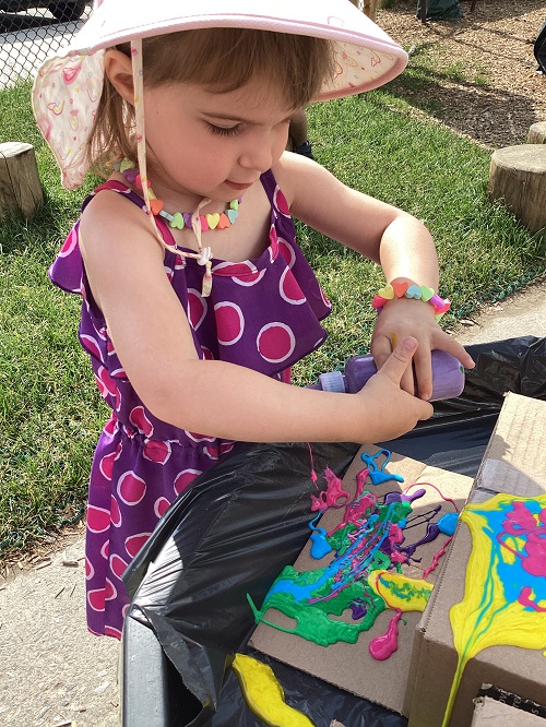 A child exploring with coloured glue