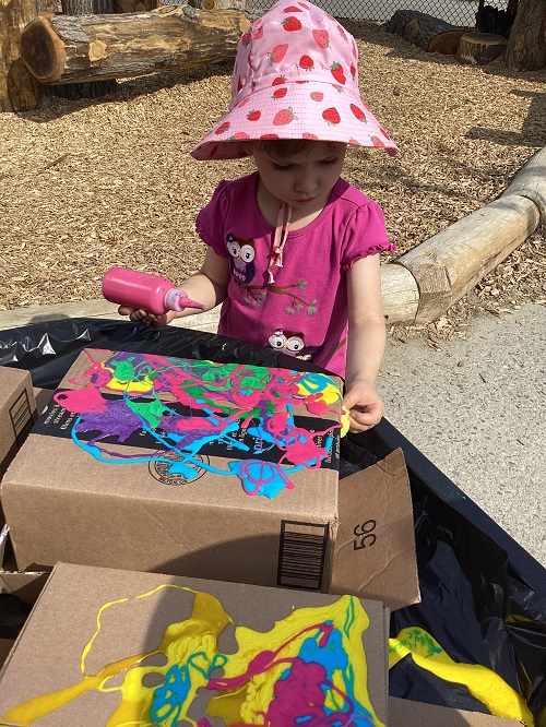 A child exploring with coloured glue