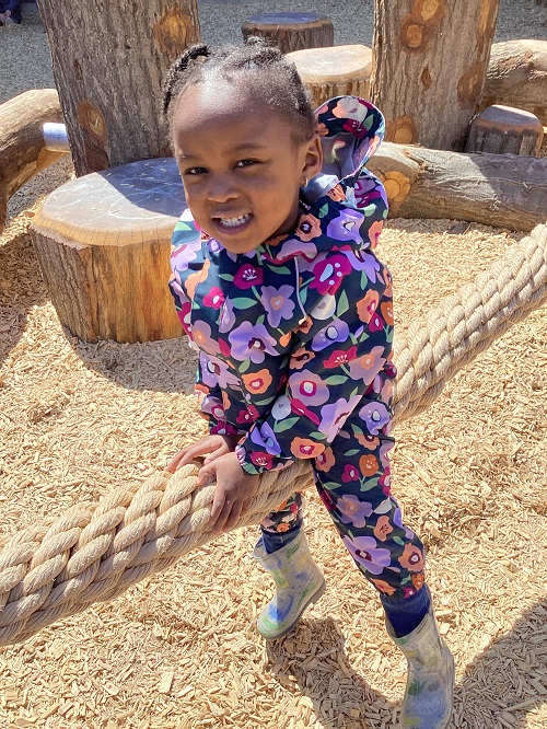 A child sitting on the manilla rope