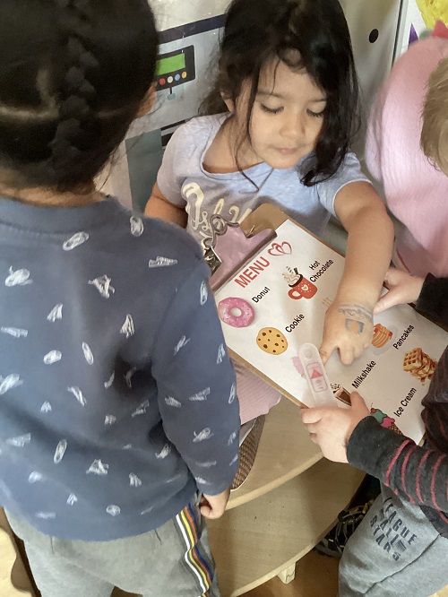 A child pointing to a picture of a food item on a clipboard