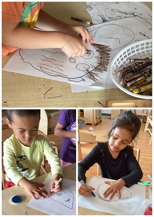 Children sitting and using art materials while drawing.