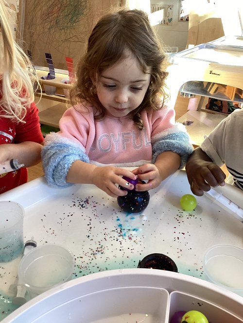 A child exploring with loose parts.