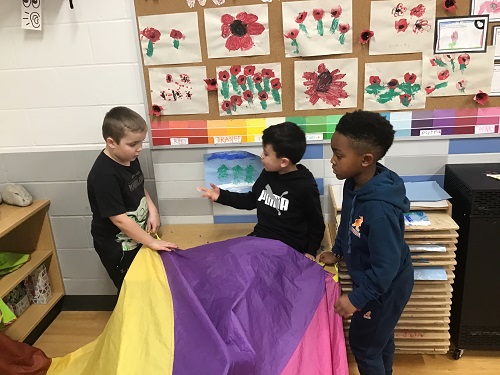 A small group of children collaborating as they build a fort
