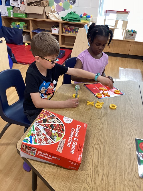 Two children playing a game of tic-tac-toe