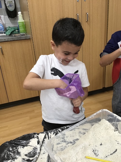 A child filling their balloon with flour