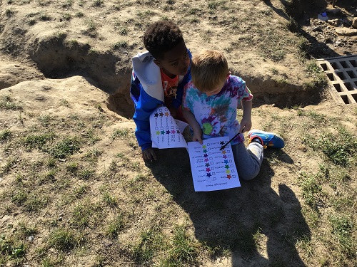 Two children working together to complete their check-lists.