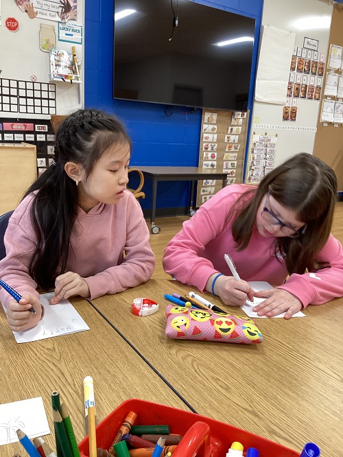 Two children creating valentine's cards