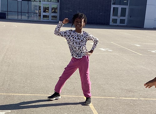 A child demonstrating some dance moves on the playground.