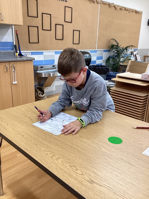 School age child working at a table 