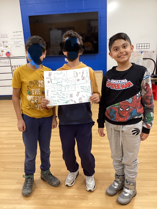Three children displaying a food poster they created