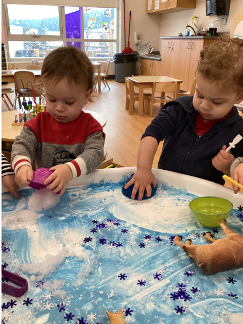 Children engaging with items in the Arctic tuff-tray.