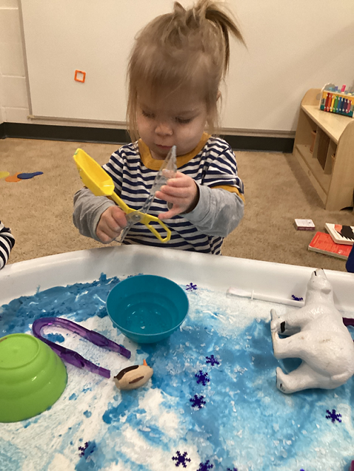 A child engaging with the Artic tuff-tray.