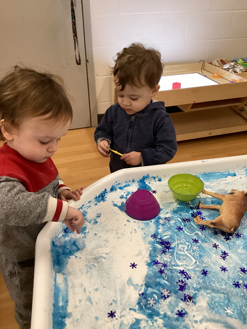 Children engaging with items in the Arctic tuff-tray.