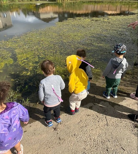 A small group of children observing a pond.