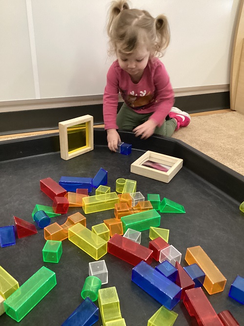 A child exploring with different shapes and sizes of blocks