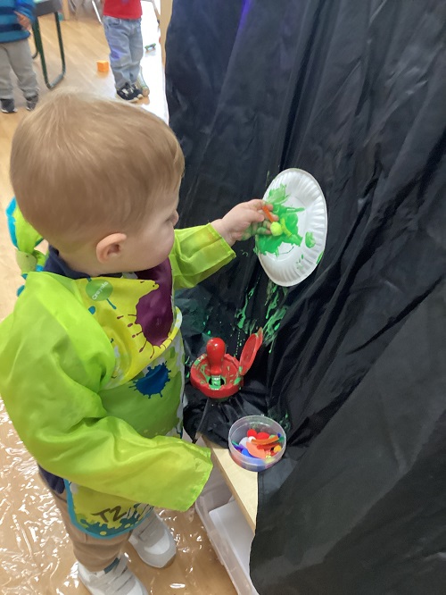 A child painting their paper plate.