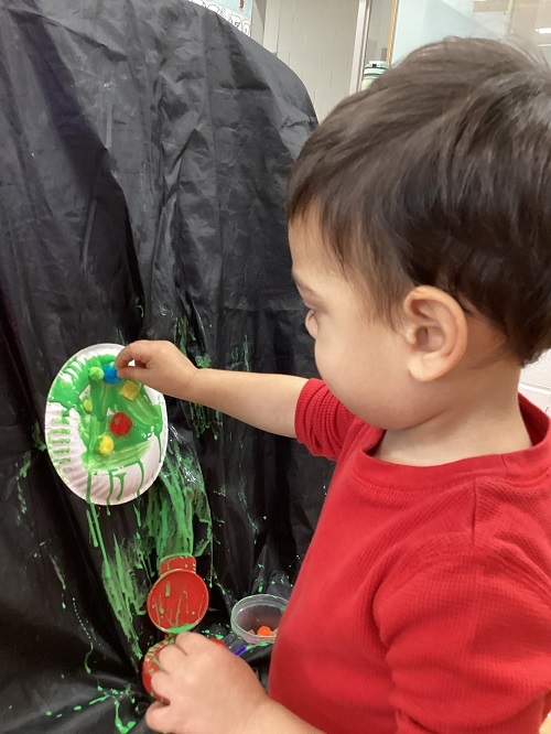 A child painting their paper plate.