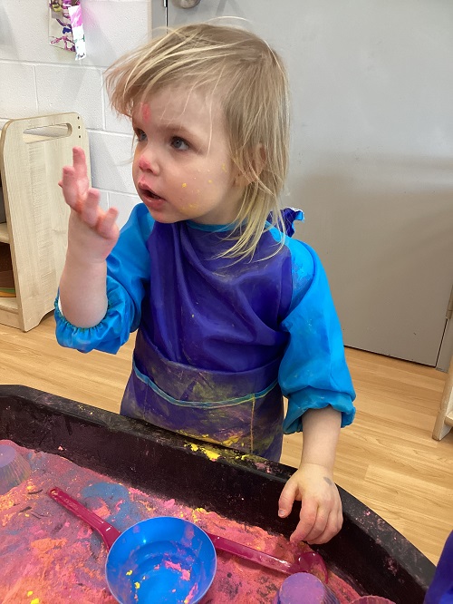 Toddler children playing with colourful powder for Holi