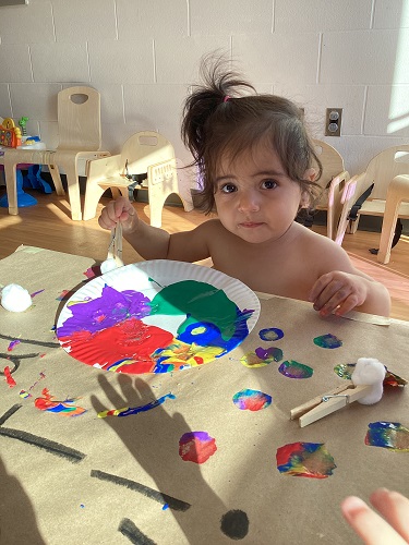 A child exploring with paint.