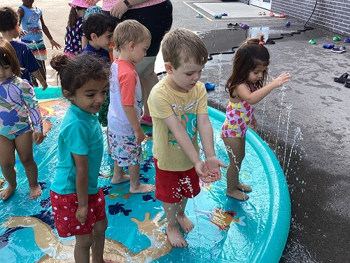 a group of children engaging in water-play.