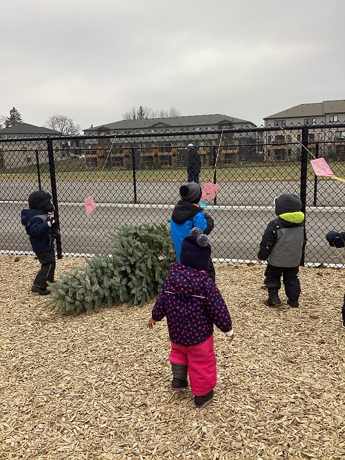 A small group of children observing their kites while on the playground.