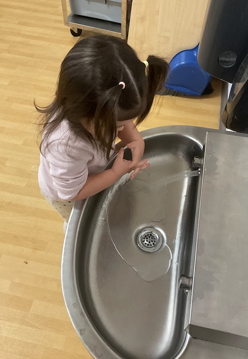 Child at sink washing hands