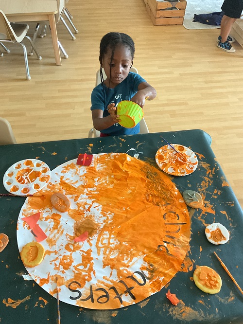 child painting orange sign