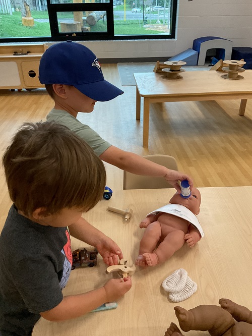 boys giving their dolls a check up