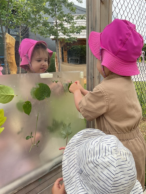 childing sticking leaves to mirror