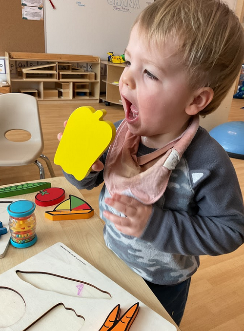 child eating yellow apple