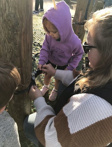 Working together to put ratchet straps on a pole