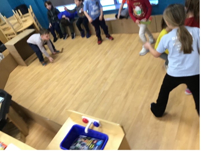 Children playing hockey in the classroom for the Olympic Games project