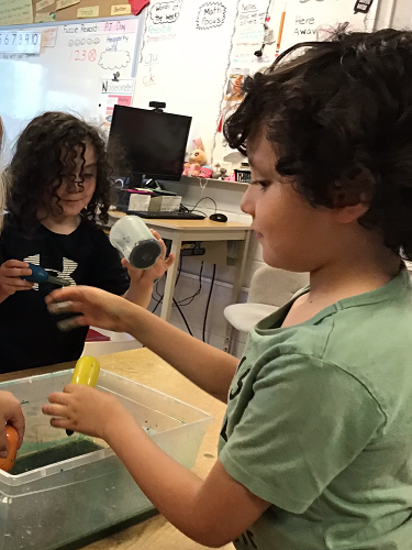 children experimenting with coloured water and oil