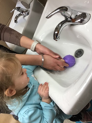 A child filling up a balloon with water