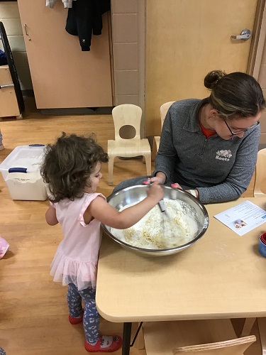 A child stirring a large bowl of baking ingredients