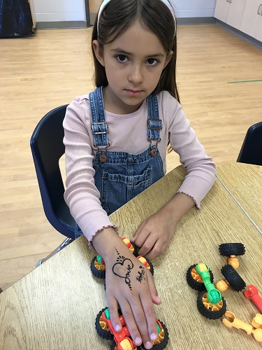 A child showing the henna tattoo on her hand