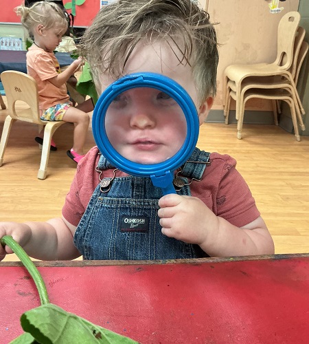 Child looking through magnifying glass