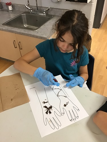 A child learning how to do Henna on paper