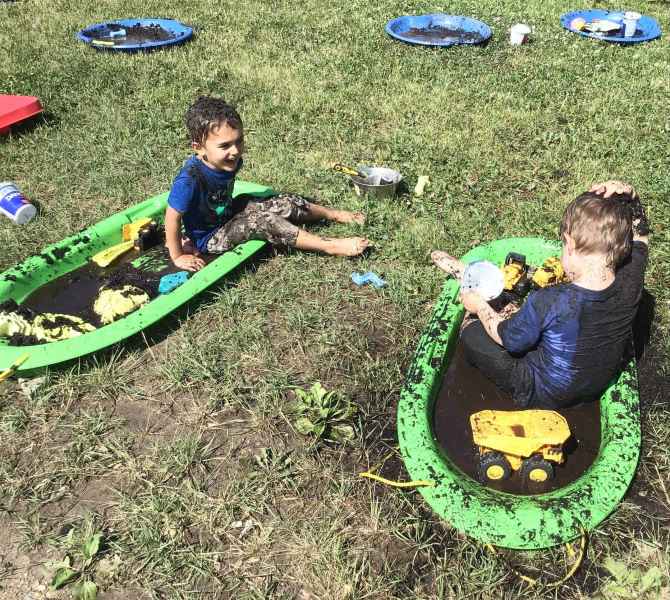 boys sitting in their own mud-filled sled