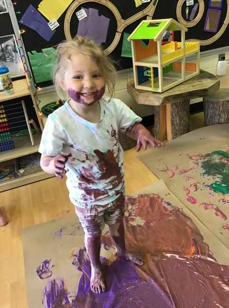 smiling girl covered in paint