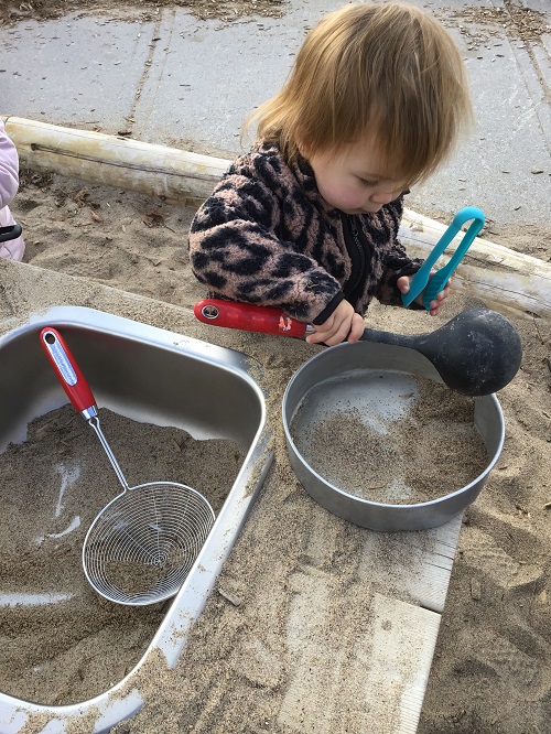 child with ladel and pan